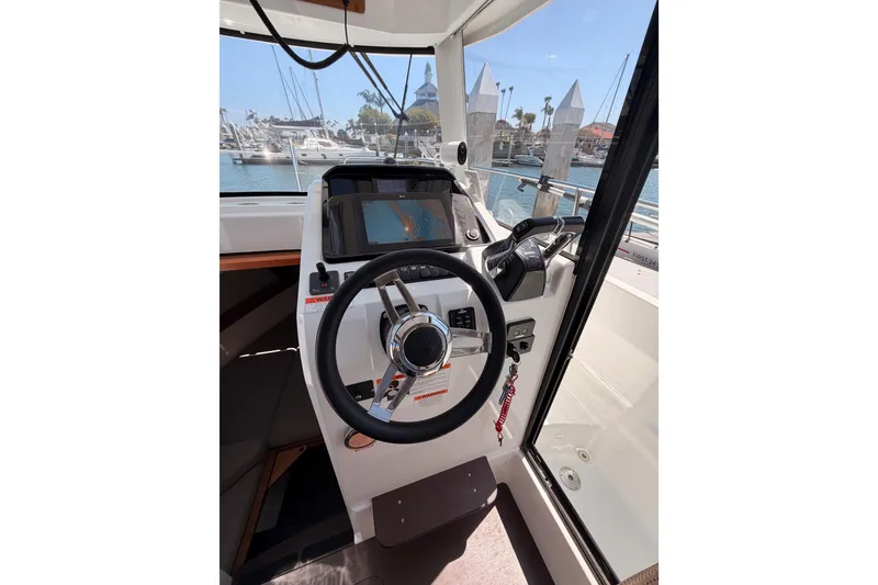 Slide: The Image of Helm of 2017 Jeanneau Merry Fisher 855 Marlin with steering wheel and navigation controls. - 45