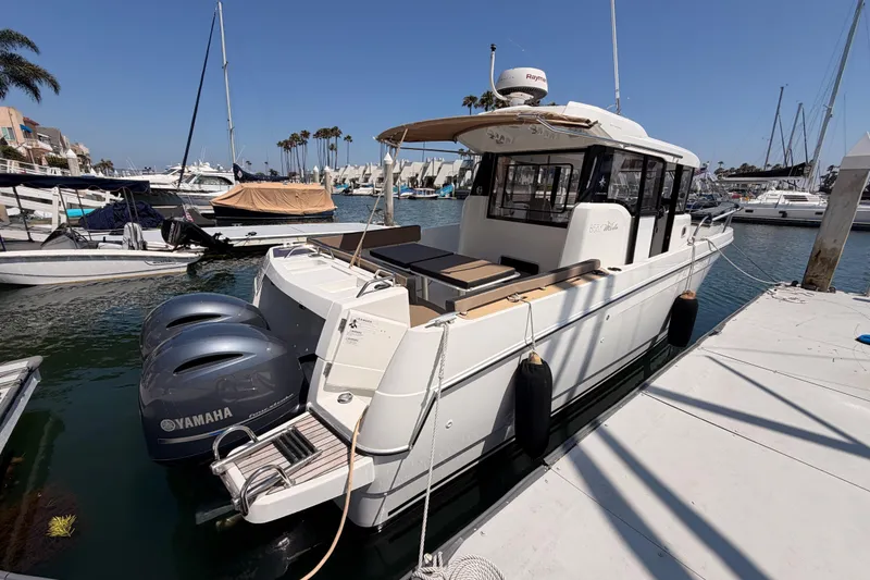 Slide: The Image of 2017 Jeanneau Merry Fisher 855 Marlin docked, featuring twin Yamaha engines, in a sunny marina. - 5