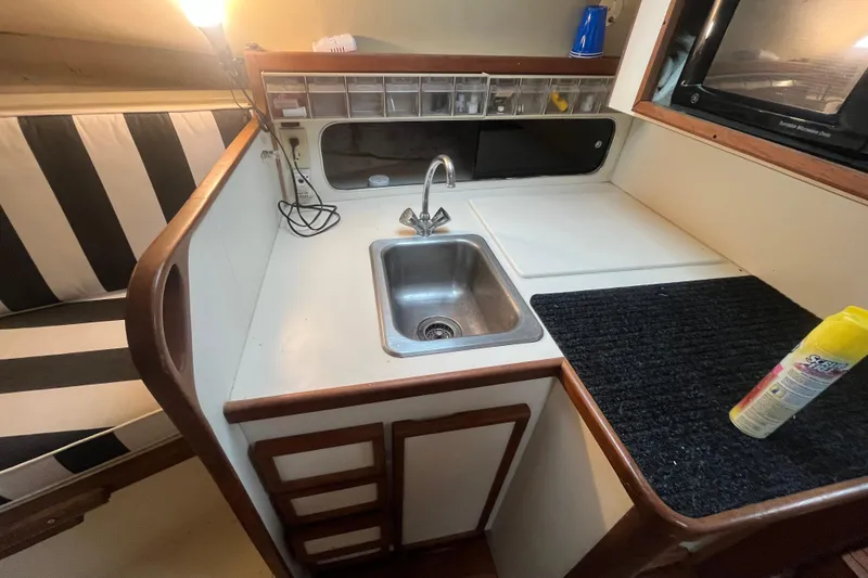 Slide: The Image of 1989 Blackfin 31 Combi interior with kitchenette, sink, and wooden cabinetry. - 13