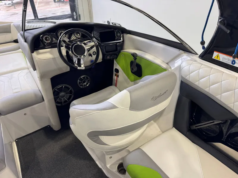 Slide: The Image of Interior of a 2014 Tigé Z1 boat with steering wheel and seats. - 22