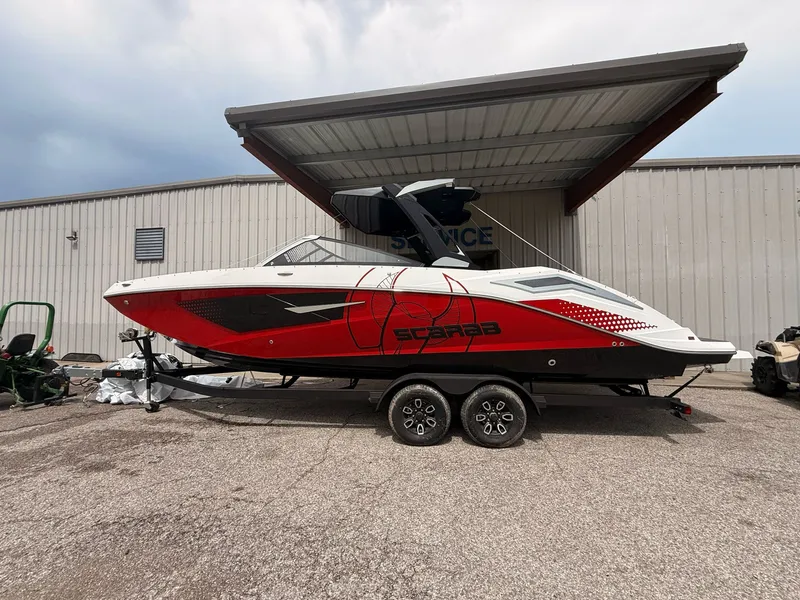 Slide: The Image of 2026 Scarab 285 LX boat in red and white on trailer. - 10