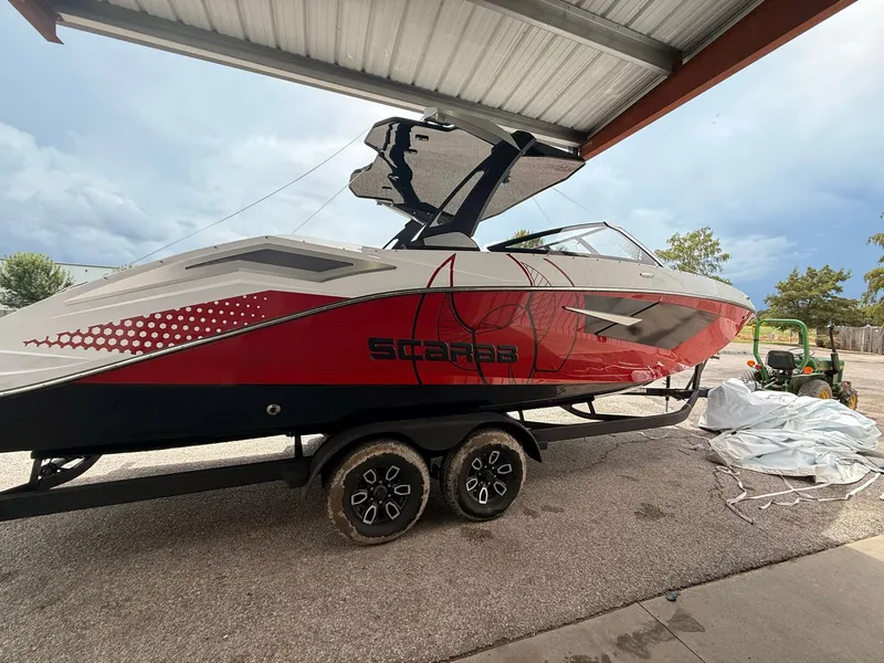 Slide: The Image of 2026 Scarab 285 LX boat on trailer under shelter. - 12