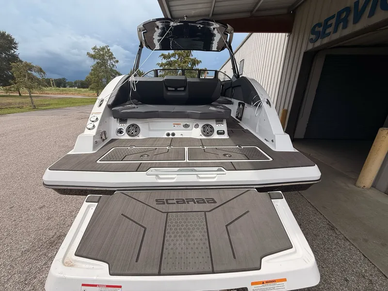 Slide: The Image of Rear view of 2026 Scarab 285 LX boat on a parking lot. - 14
