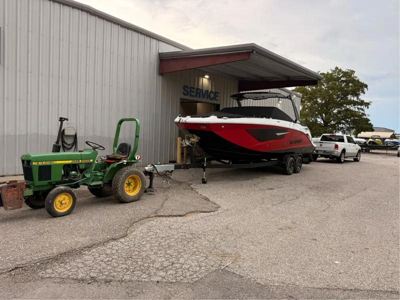 Slide: The Image of 2026 Scarab 285 LX boat outside service building with tractor. - 6