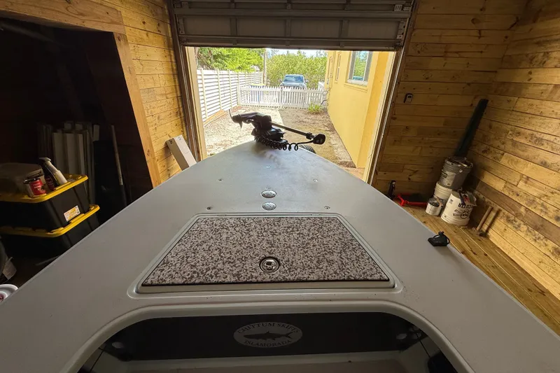 Slide: The Image of 2025 Chittum Skiffs 18 Islamorada boat in wooden garage, front view. - 14