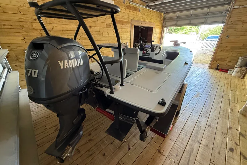 Slide: The Image of 2025 Chittum Skiffs 18 Islamorada with Yamaha 70 engine in wooden garage. - 19