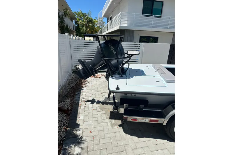 Slide: The Image of 2025 Chittum Skiffs 18 Islamorada boat with Yamaha engine, parked on a paved driveway. - 3