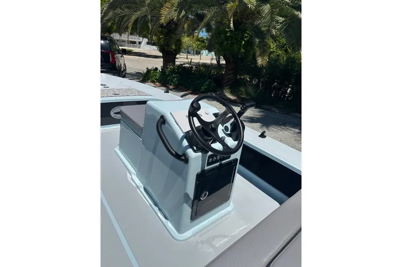 Slide: The Image of 2025 Chittum Skiffs 18 Islamorada boat console with steering wheel, outdoors. - 5