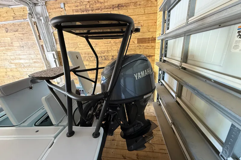 Slide: The Image of 2025 Chittum Skiffs 18 Islamorada with Yamaha outboard motor in a wooden garage. - 18