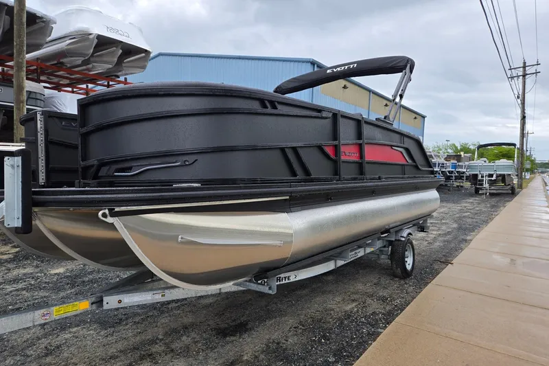 The Image of 2026 Evotti 721QL pontoon boat on trailer, parked outdoors near a warehouse. - 0