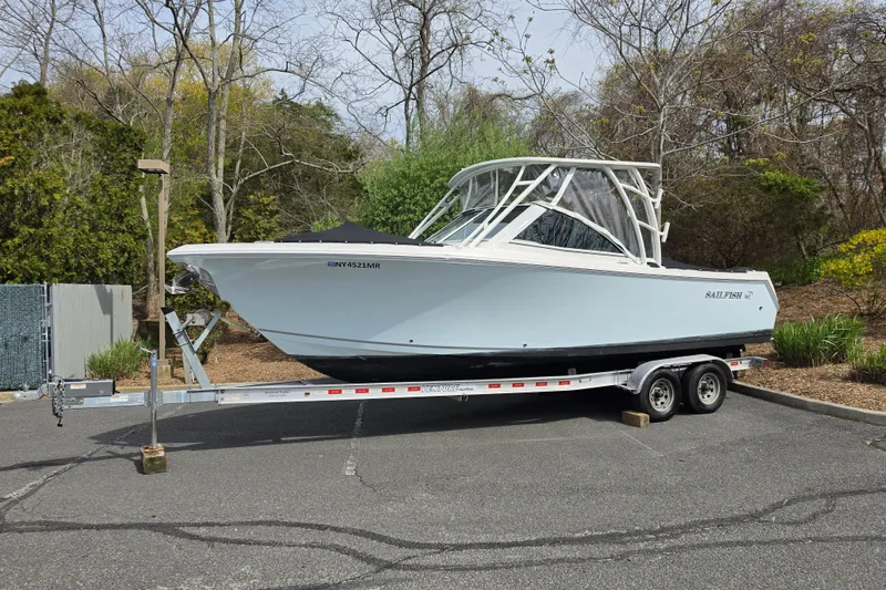 The Image of 2019 Sailfish 275 DC boat on trailer in a parking lot. - 0