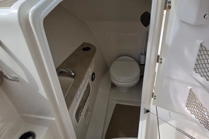Slide: The Image of 2019 Sailfish 275 DC boat interior bathroom with toilet and sink. - 11