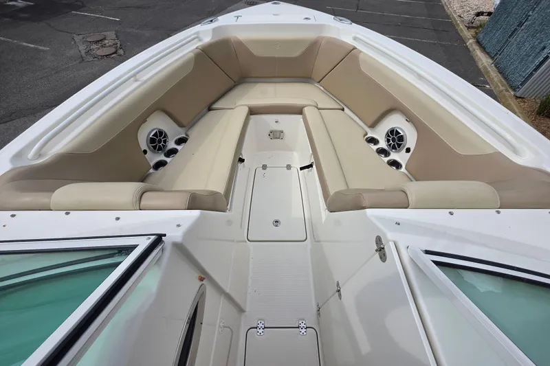 Slide: The Image of 2019 Sailfish 275 DC boat interior with beige seating and built-in speakers. - 13