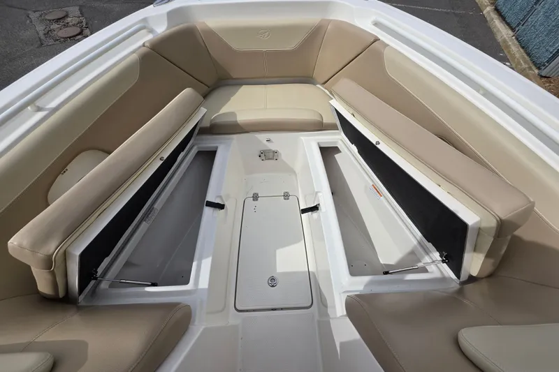 Slide: The Image of 2019 Sailfish 275 DC boat interior with beige seating and open storage compartments. - 14