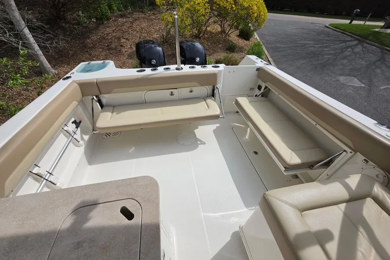 Slide: The Image of 2019 Sailfish 275 DC boat interior with beige seating and dual outboard motors. - 4