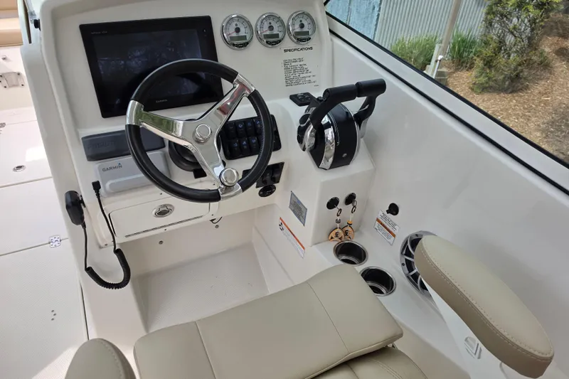Slide: The Image of 2019 Sailfish 275 DC boat helm with steering wheel, controls, and navigation display. - 7