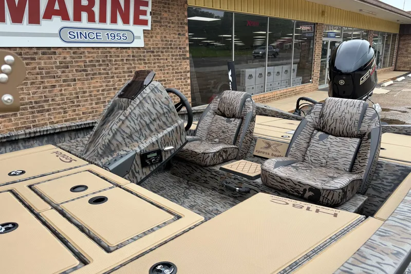 Slide: The Image of 2026 Xpress H18C Crappie boat with camo seats, displayed outside a marine store. - 3