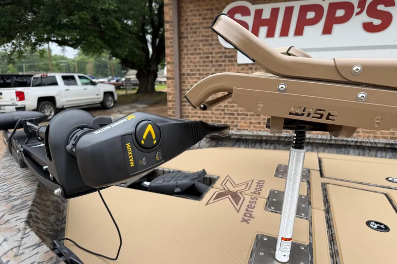 Slide: The Image of 2026 Xpress H18C Crappie boat with Minn Kota Maxxum motor and Wise seat, parked outside. - 9