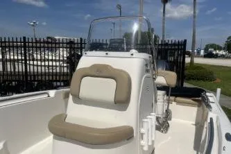 Slide: The Image of 2014 Key West 189 FS boat with beige seating, parked outdoors under a clear sky. - 11