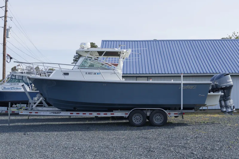 The Image of 2020 Parker 2810 XLD Walkaround boat on trailer, parked near a building with blue roof. - 0