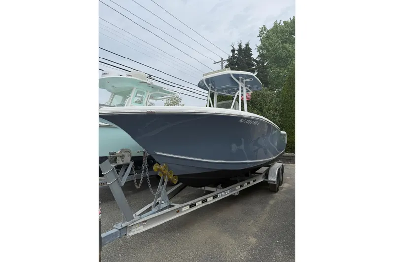 The Image of 2015 Tidewater 232 CC Adventure boat on trailer, parked outdoors. - 1