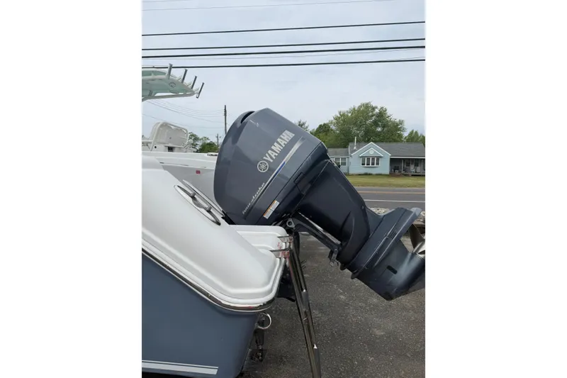 Slide: The Image of 2015 Tidewater 232 CC Adventure boat with Yamaha outboard motor, parked on pavement. - 3