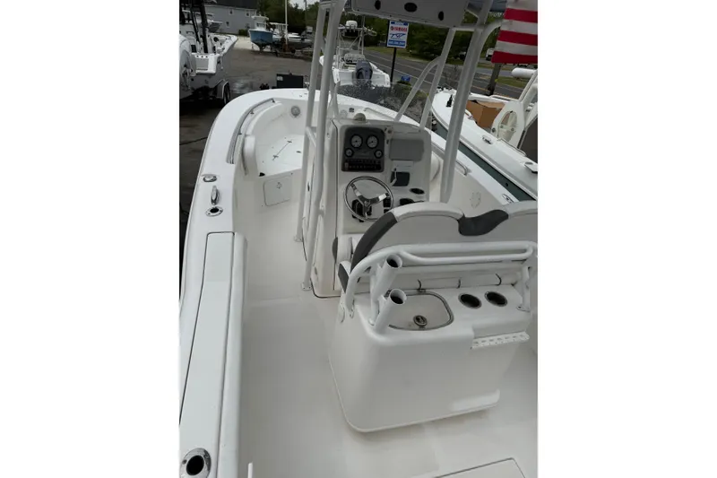 Slide: The Image of 2015 Tidewater 232 CC Adventure boat interior with helm, seating, and fishing rod holders. - 6