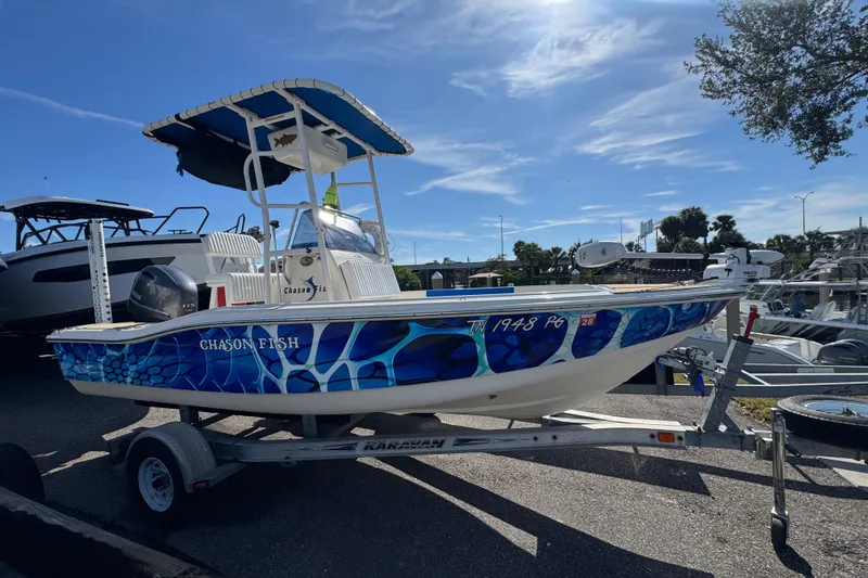 The Image of 2005 Scout 175 Sportfish boat with vibrant blue design on a trailer under clear skies. - 0