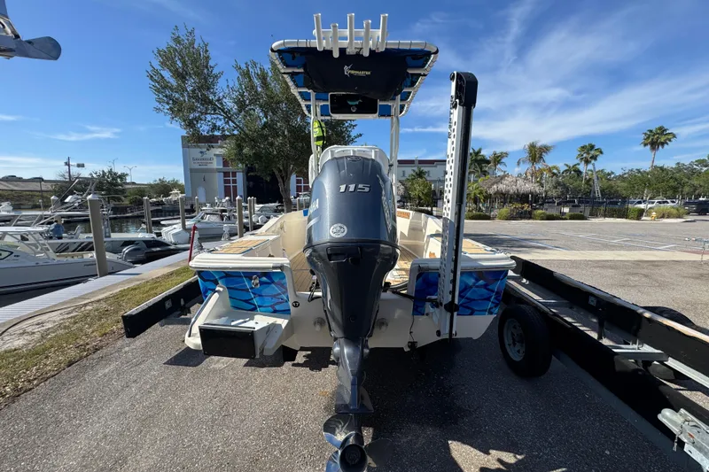 Slide: The Image of 2005 Scout 175 Sportfish boat with Yamaha 115 engine on trailer, marina background. - 13