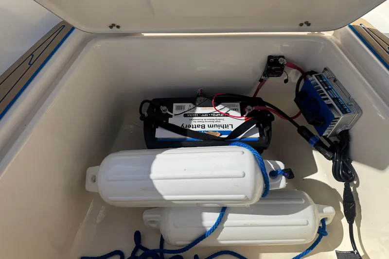 Slide: The Image of Open storage compartment of 2005 Scout 175 Sportfish with lithium battery and boat fenders. - 5