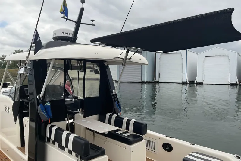 Slide: The Image of 2004 Rivolta PT Runner 4.0 boat docked, featuring striped seating and a canopy. - 14