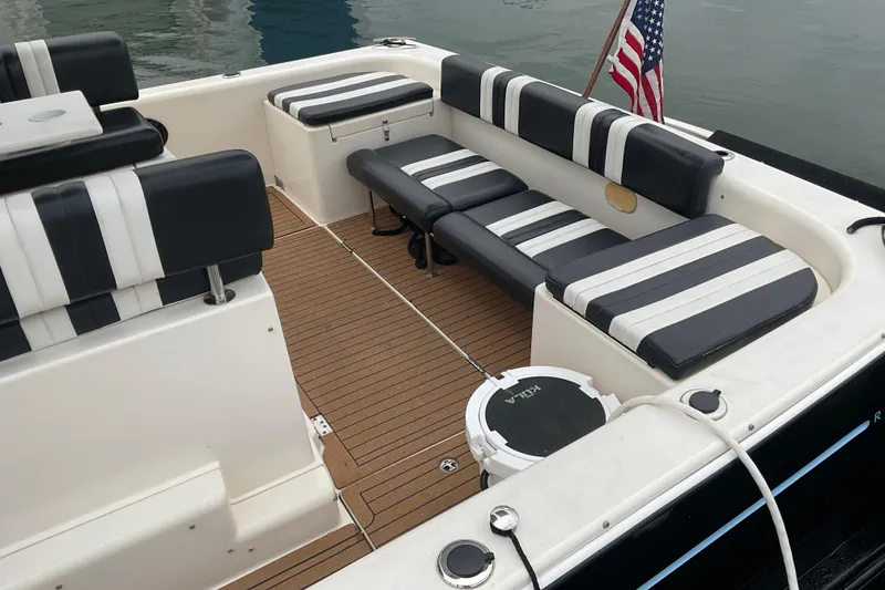 Slide: The Image of 2004 Rivolta PT Runner 4.0 boat interior with striped seating and American flag. - 16