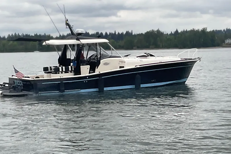 Slide: The Image of 2004 Rivolta PT Runner 4.0 boat on a calm lake with overcast skies. - 2