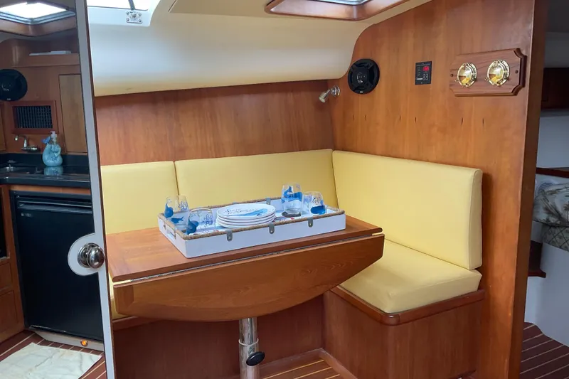 Slide: The Image of Cozy dining area in 2004 Rivolta PT Runner 4.0 yacht with wooden interior and yellow seating. - 22