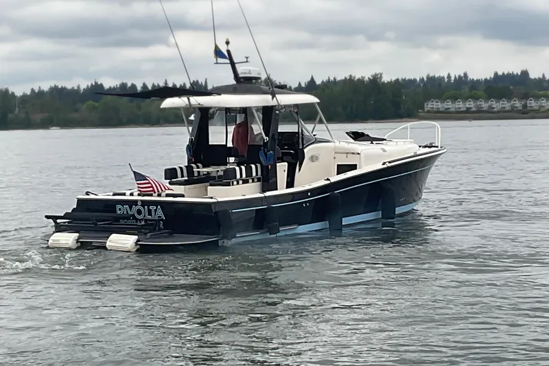 Slide: The Image of 2004 Rivolta PT Runner 4.0 boat cruising on a calm lake under cloudy skies. - 3