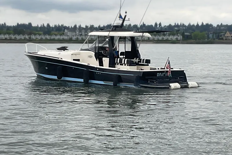 Slide: The Image of 2004 Rivolta PT Runner 4.0 boat cruising on a calm lake under cloudy skies. - 6