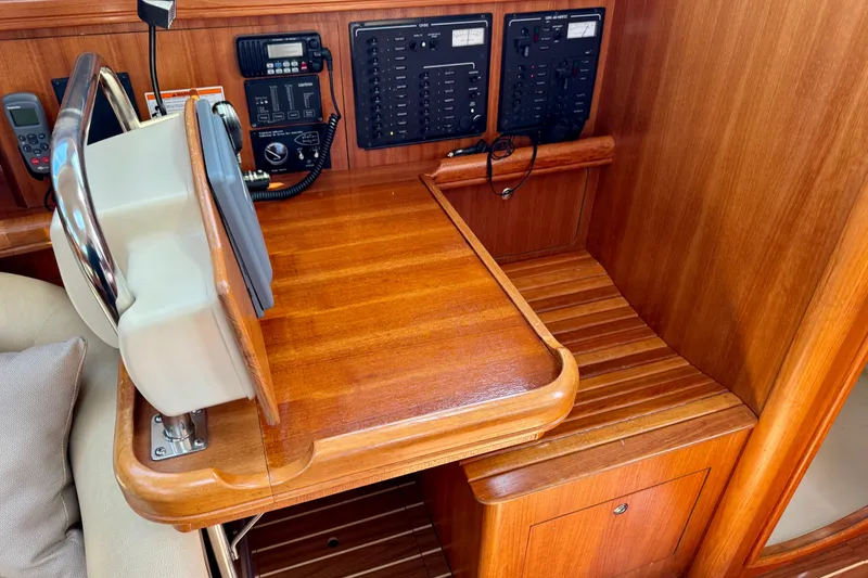 Slide: The Image of 2007 Hunter 41 Deck Salon navigation station with wooden finish and control panels. - 15