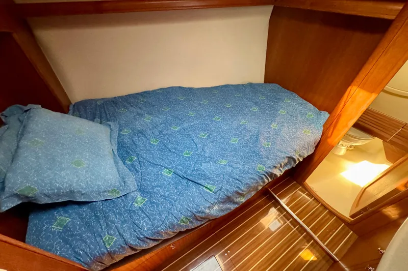 Slide: The Image of Cozy cabin interior of 2007 Hunter 41 Deck Salon with blue bedding and wooden accents. - 18