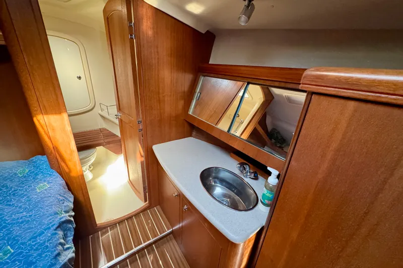 Slide: The Image of Interior of 2007 Hunter 41 Deck Salon yacht with wooden cabinetry and compact bathroom. - 19