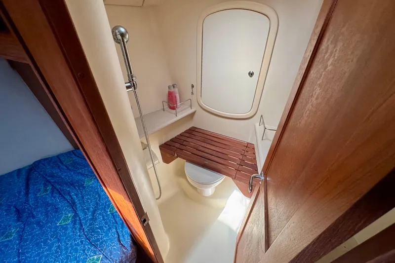 Slide: The Image of 2007 Hunter 41 Deck Salon bathroom with shower, wooden seat, and adjacent cabin. - 20