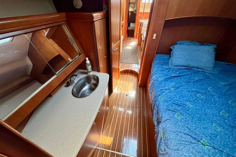 Slide: The Image of 2007 Hunter 41 Deck Salon interior with bed, sink, and wooden flooring. - 22