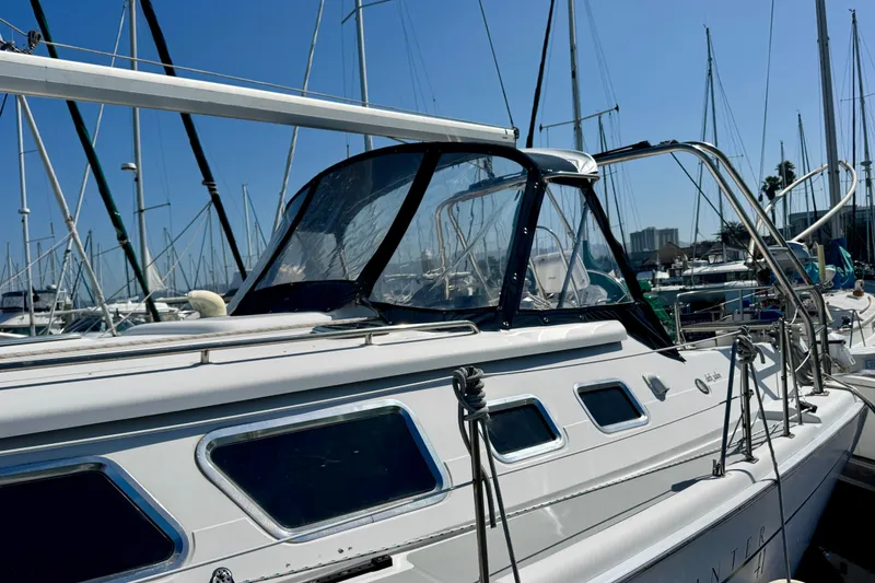 Slide: The Image of 2007 Hunter 41 Deck Salon sailboat docked in a marina under clear blue skies. - 29