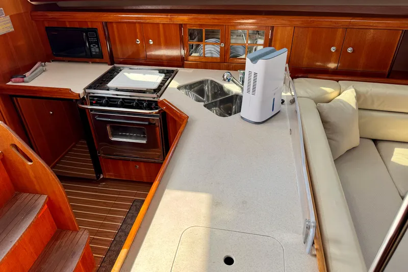 Slide: The Image of 2007 Hunter 41 Deck Salon interior with kitchen, stove, sink, and seating area. - 7