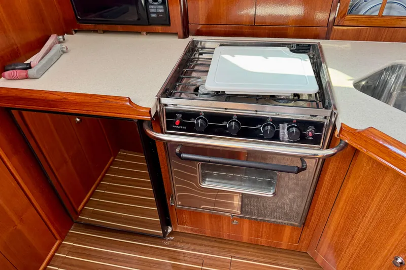 Slide: The Image of 2007 Hunter 41 Deck Salon kitchen with stove, wooden cabinetry, and countertop. - 9