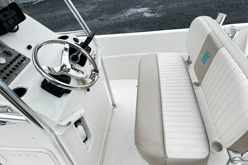 Slide: The Image of 2017 Carolina Skiff 238DLV boat interior with steering wheel and cushioned seating. - 7