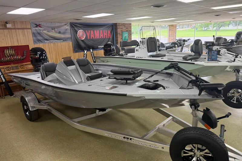 The Image of 2026 Xpress H18C Crappie boat displayed indoors on a trailer. - 1