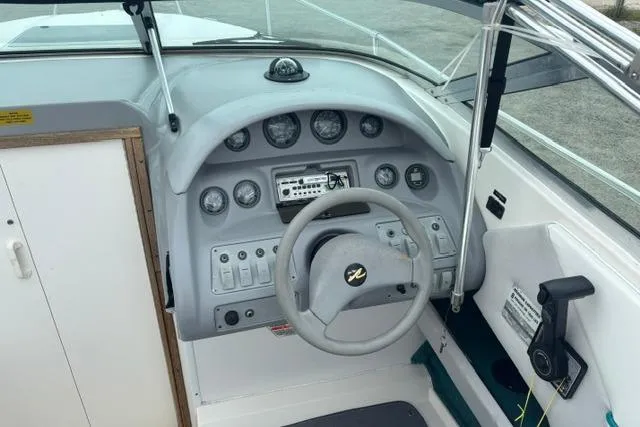 Slide: The Image of 1994 Sea Ray 240 boat dashboard with steering wheel and instrument panel. - 14