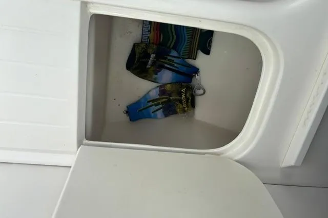 Slide: The Image of Storage compartment on a 1994 Sea Ray 240 boat with colorful items inside. - 15