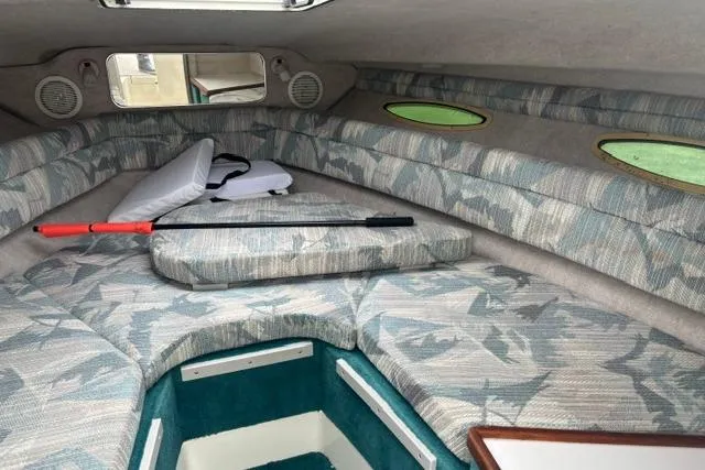 Slide: The Image of 1994 Sea Ray 240 boat cabin with patterned upholstery and storage compartments. - 16