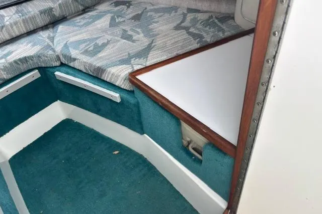 Slide: The Image of Interior cabin of 1994 Sea Ray 240 boat with teal carpet and patterned cushions. - 18